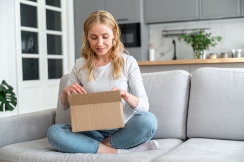 Woman opening a delivery box at home